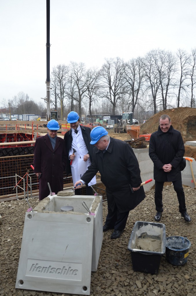Le docteur Peter Schönknecht, directeur de l’hôpital d’Arnsdorf (au centre), Alf-Rüdiger König et Volker Kylau du ministère des Finances de Saxe à gauche coiffés de casques pour la pose de la première pierre